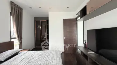 Modern bedroom with sleek furniture and large wardrobe in a stylish apartment.