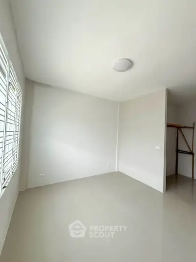 Spacious empty room with large windows and tiled floor, ready for customization.