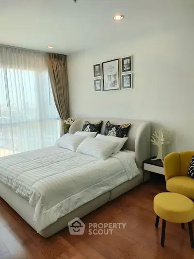 Luxurious bedroom with elegant decor and large windows offering natural light