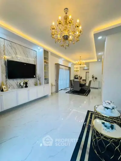 Luxurious living room with elegant chandeliers and marble accents, perfect for sophisticated gatherings.