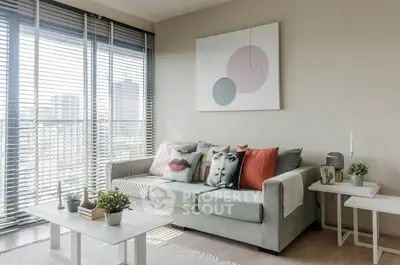 Modern living room with stylish decor and large windows offering city views.