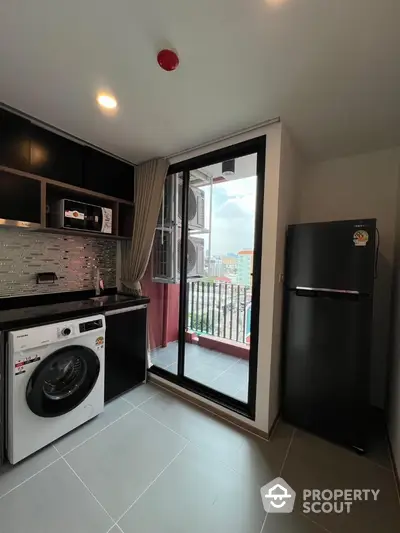 Modern kitchen with appliances and balcony view in urban apartment