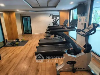 Modern gym with state-of-the-art fitness equipment and wooden flooring