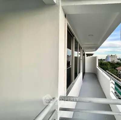 Spacious balcony with modern railing and city view, perfect for relaxation and enjoying the skyline.