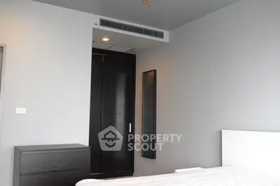 Modern minimalist bedroom with sleek black door and neutral tones