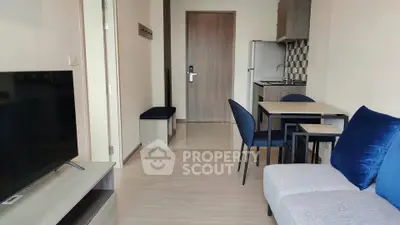 Modern living room with open kitchen, stylish furniture, and sleek design in a cozy apartment.