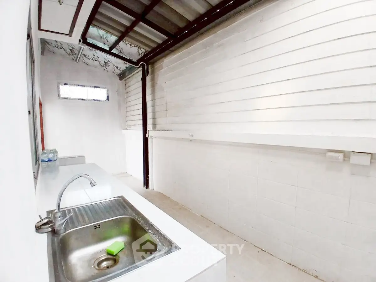 Spacious utility area with sink and ample counter space in modern home.