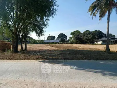 Spacious land plot with trees and clear sky, ideal for development.
