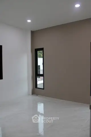 Spacious empty room with modern design and large windows for natural light.