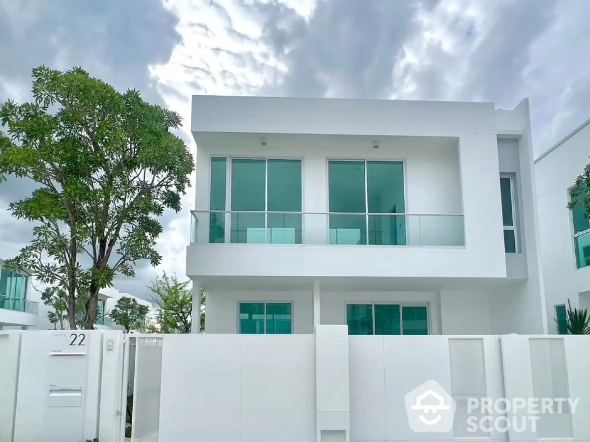 Modern white two-story house with large windows and minimalist design