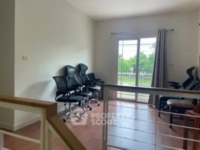 Bright study room with modern chairs and large window overlooking greenery.