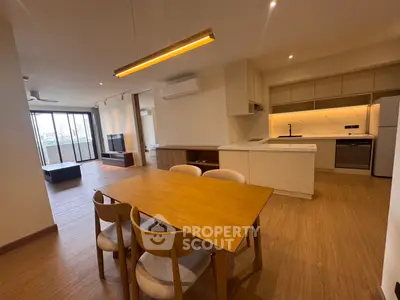 Spacious open-plan living and dining area with modern kitchen in a stylish apartment.