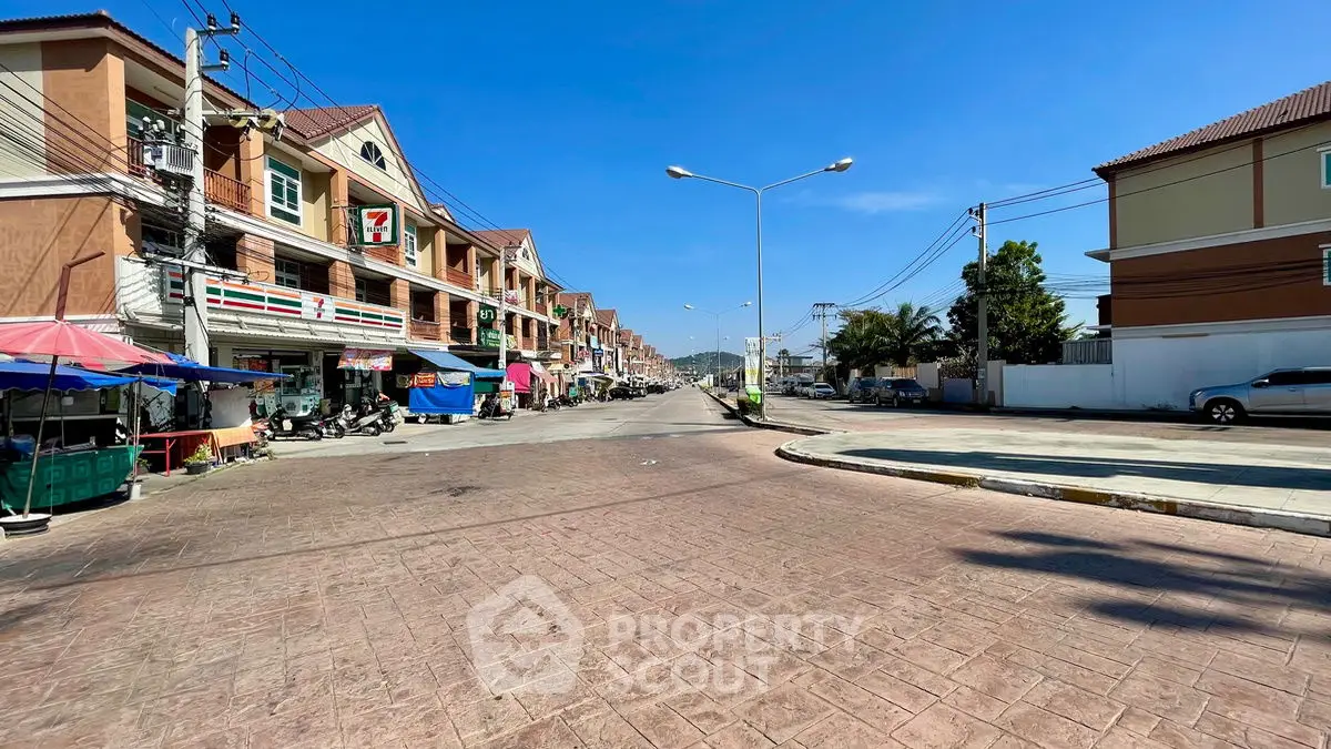 Charming street view with row of townhouses and clear blue sky, perfect for urban living.