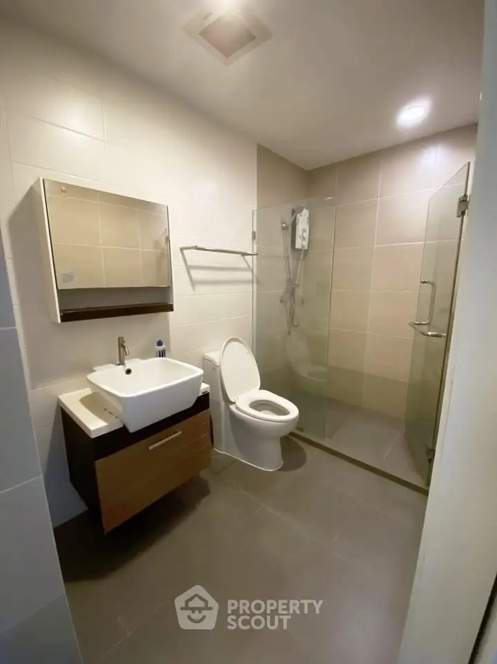 Modern bathroom with glass shower and sleek fixtures in a contemporary home.