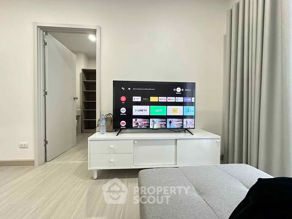 Modern living room with sleek TV setup and stylish furniture in a contemporary apartment.