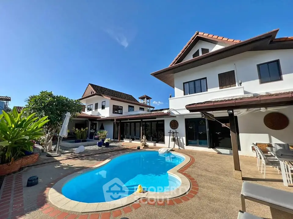 Stunning villa with private pool and spacious outdoor area under clear blue skies.