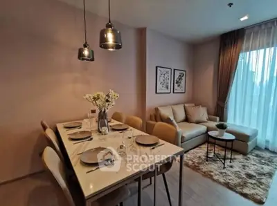 Modern living room with elegant dining area and cozy seating, featuring stylish lighting and decor.