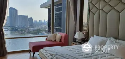 Luxurious bedroom with stunning city and river view from floor-to-ceiling windows.