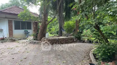 Charming garden view with lush greenery and rustic patio, perfect for relaxation and outdoor activities.