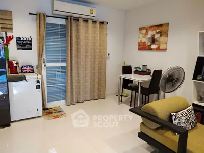 Cozy living room with modern decor, air conditioning, and dining area in a stylish apartment.