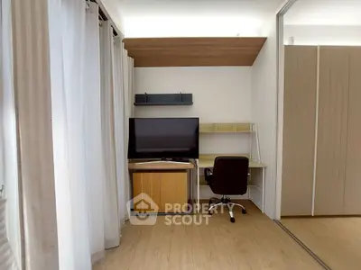 Modern study area with desk, chair, and TV in a stylish apartment.