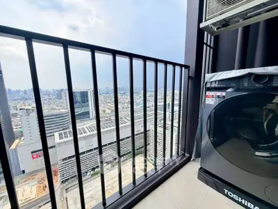 Stunning city view from high-rise balcony with modern washing machine.