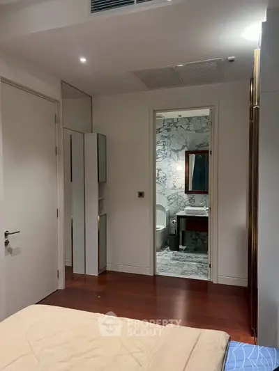 Modern bedroom with ensuite marble bathroom and wooden flooring