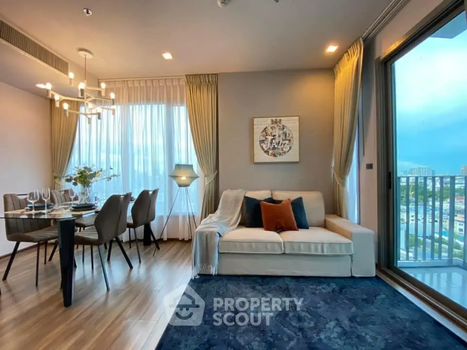 Luxurious living room with elegant dining area and stunning city view from balcony.