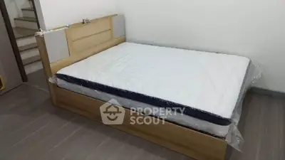 Spacious bedroom with a new mattress on a wooden bed frame, perfect for restful nights.