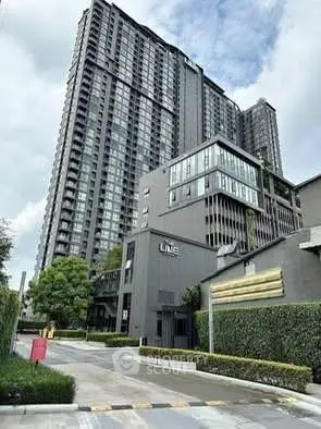 Modern high-rise condominium with sleek architecture and lush greenery