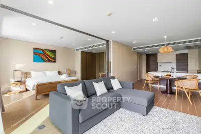 Spacious open-plan living room with modern kitchen and cozy bedroom area, perfect for contemporary living.