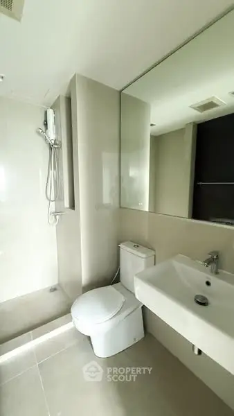 Modern bathroom with sleek fixtures and large mirror in a contemporary apartment.