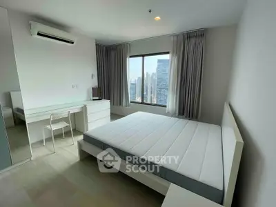 Modern bedroom with city view, featuring minimalist furniture and large window for natural light.