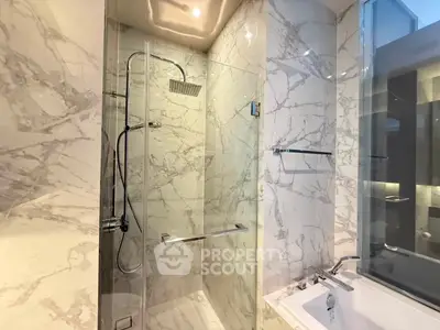 Luxurious marble bathroom with modern shower and bathtub in elegant real estate property.