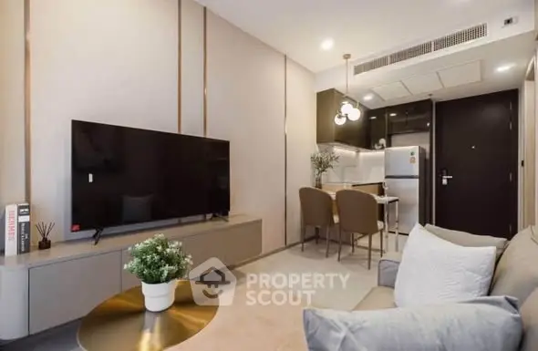 Modern living room with sleek TV setup and cozy dining area in stylish apartment.