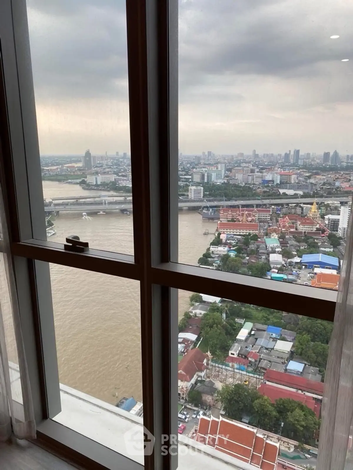 Stunning high-rise view of river and cityscape from a modern apartment window.
