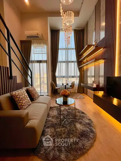 Luxurious high-ceiling living room with elegant chandelier and modern decor in a stylish apartment.