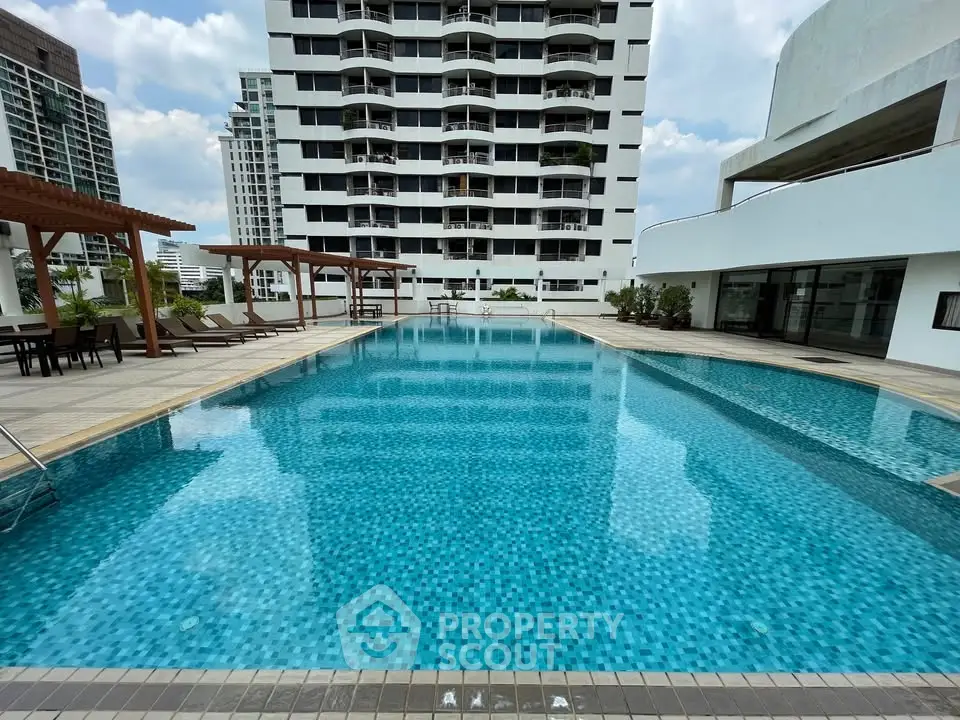 Luxurious rooftop pool with stunning city views in modern high-rise building.