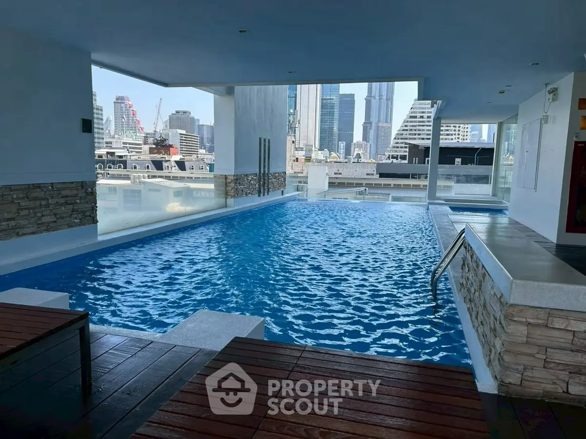 Luxurious indoor pool with stunning city skyline view, perfect for relaxation and leisure in a modern urban setting.