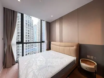 Modern bedroom with large window offering stunning city views in a high-rise apartment.