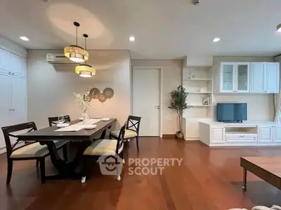 Elegant living room with dining area, wooden flooring, and modern decor.