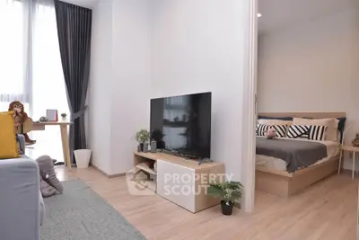 Modern living room with stylish decor and adjacent cozy bedroom in a contemporary apartment.