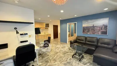 Modern living room with sleek furniture and open kitchen layout, featuring stylish decor and ample lighting.