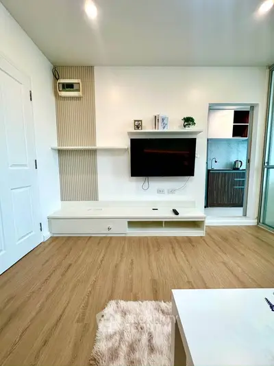 Modern living room with wall-mounted TV and sleek wooden flooring