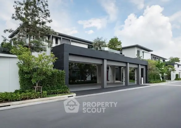 Modern luxury residential building with sleek design and lush greenery.