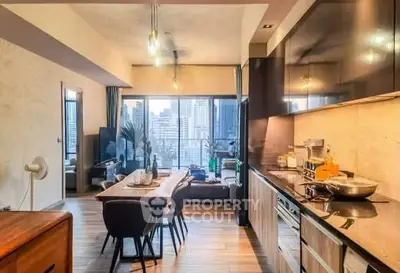 Modern open-layout kitchen and living room with city view, stylish decor, and natural lighting.