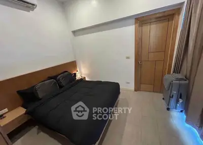 Cozy bedroom with modern decor and wooden accents, featuring a comfortable bed and stylish lighting.