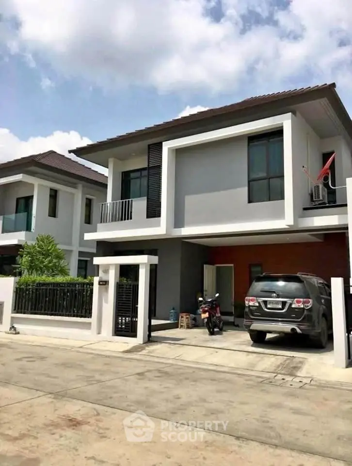 Modern two-story house with driveway and garage in a suburban neighborhood.