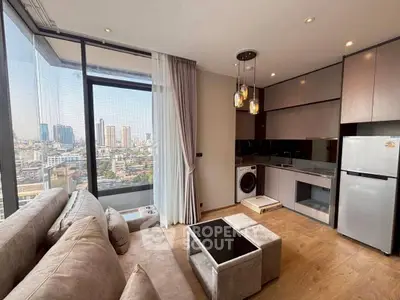 Modern living room with city view, featuring sleek kitchen and cozy seating area.