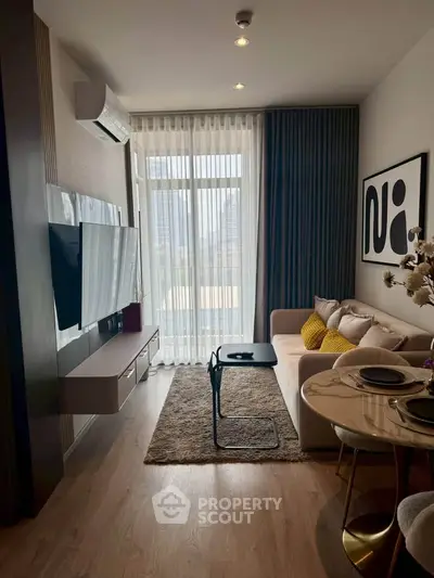 Modern living room with stylish decor and large window offering natural light.